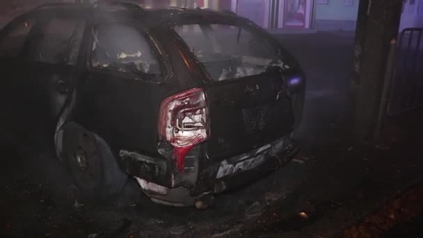 城市街道上的一名男子企图用灭火器扑灭一场大火 但被完全烧毁了的汽车失火 — 图库视频影像
