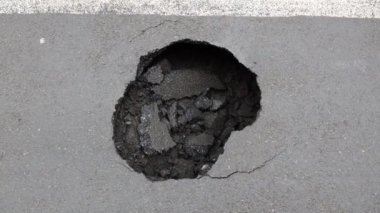 Yolun kaldırımındaki delikte bir lastik su sıçratıyor engebeli bir yolculuk için. Ukrayna dnepr dinnipro
