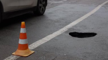 Yolun kaldırımındaki delikte bir lastik su sıçratıyor engebeli bir yolculuk için. Ukrayna dnepr dinnipro