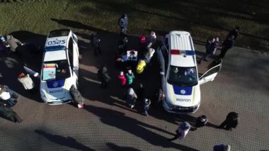 Dnipro, Ukrayna - Devriye arabası şehir parkındaki ağaçların arkasına park edilmiş. Ilık bahar günü. Çevredeki ağaçlarda taze yeşiller