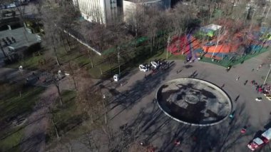 Dnipro, Ukrayna - Devriye arabası şehir parkındaki ağaçların arkasına park edilmiş. Ilık bahar günü. Çevredeki ağaçlarda taze yeşiller