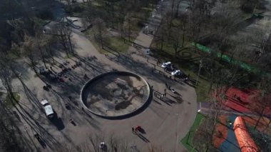 Dnipro, Ukrayna - Devriye arabası şehir parkındaki ağaçların arkasına park edilmiş. Ilık bahar günü. Çevredeki ağaçlarda taze yeşiller