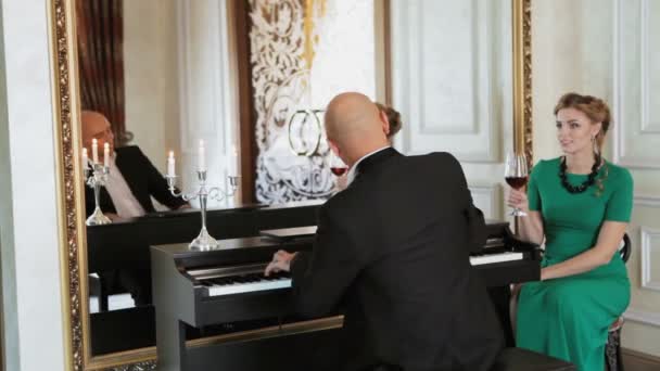 Liebespaar bei einem Date. Mann spielt Klavier. — Stockvideo