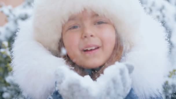 A menina sopra fora flocos de neve — Vídeo de Stock