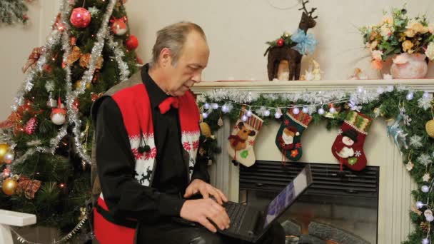 Muž, pomocí přenosného počítače. Vánoční dekorace — Stock video