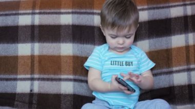 Yakışıklı küçük çocuk bir smartphone ile oynamak