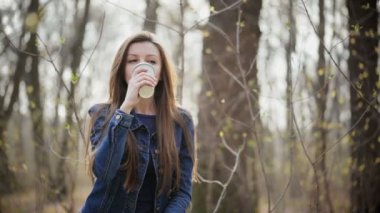 Genç kadın içecekler kahve dışarı kağıt bardak