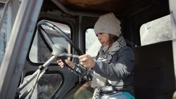 Chica joven sentada en la vieja cabina del tractor — Vídeos de Stock