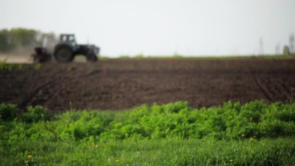 Verschwommene Sicht. Traktor fährt durch Feld — Stockvideo