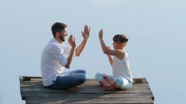 Padre juega con su hija al aire libre en el lago — Vídeo de stock
