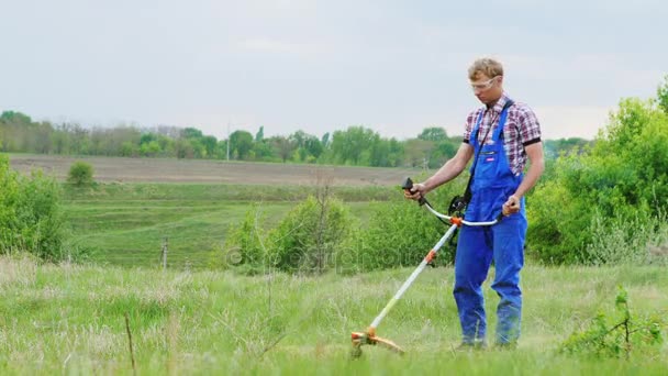 Werknemer maait gras handmatige grasmaaier — Stockvideo