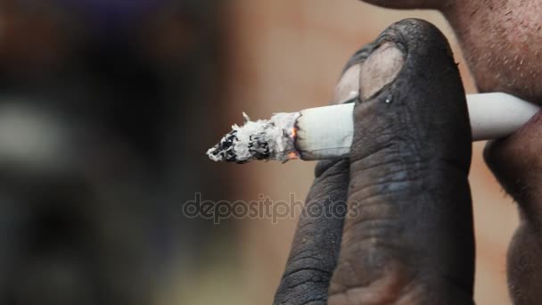 Un travailleur fume, Gros plan 