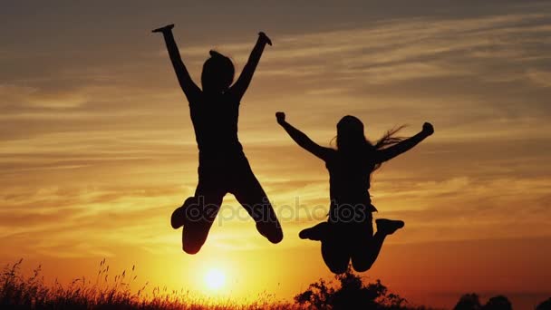 Silhouette of jumping girls at sunset. — Stock Video