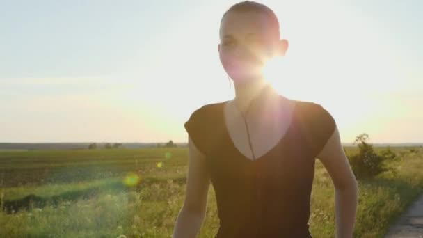 Ağır çekim: gün batımı koşu genç bir kadın — Stok video