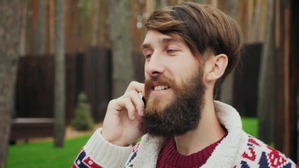Seorang pria dengan jenggot berbicara di telepon — Stok Video