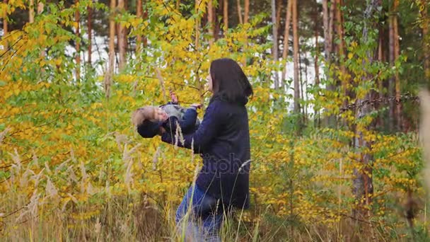Jovem mãe torce seu filho, abraços, sorrisos — Vídeo de Stock