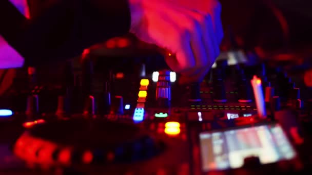 Primer plano de las manos del DJ trabajando en el control remoto en el club nocturno . — Vídeo de stock