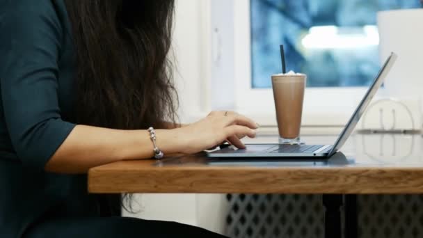 Close-up of female hands, modern business woman works on a laptop while sitting in cafe, using touchpad — Stock Video