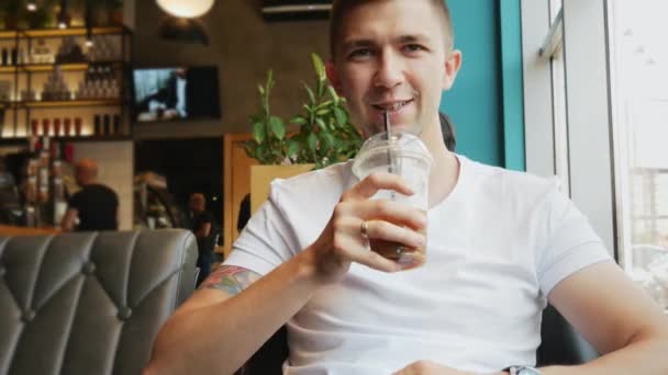 Primer plano retrato de joven feliz cliente masculino en la cafetería, hombre bebe cóctel frío — Vídeos de Stock