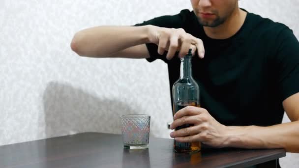 Solo hombre borracho vierte whisky en un vaso de botella y beber — Vídeos de Stock