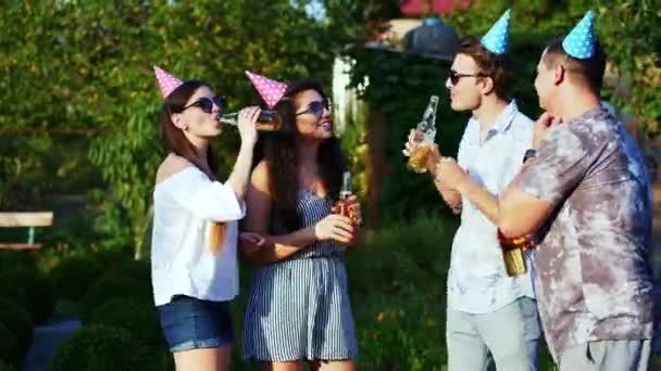 Grupo de amigos felizes clink com garrafas de cerveja na festa de verão, enquanto comemorar aniversário, conversando, dançando — Vídeo de Stock