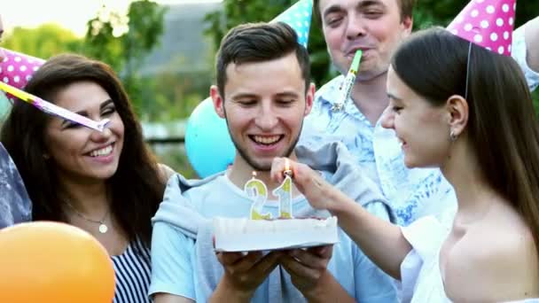 Venner gratulerer den lykkelige mannen med fødselsdagen, lyset og lysene som blåser 21 på kaken, voksenbursdagsfesten – stockvideo