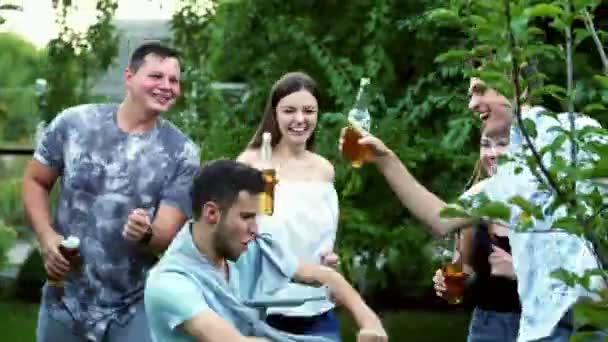 Bataille de danse folle et drôle de deux gars, amis cliquetis bouteilles, boire de la bière, sur la soirée d'été — Video