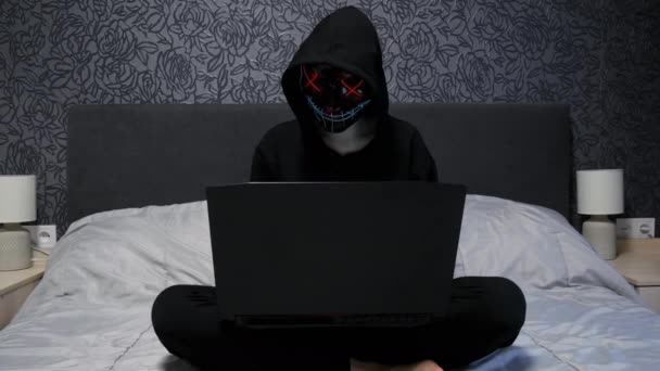 Sexy hacker mujer divertida vestida con una máscara de pasamontañas negro y sujetador con pechos magníficos trabajando en el ordenador portátil, piratería y ataque de hacker — Vídeos de Stock