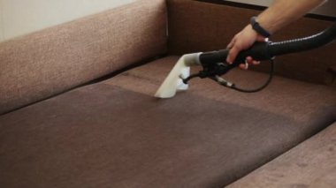 Çamaşır temizleyicisine yakın çekim kanepeyi temizler ve kiri temizler, profesyonel temizlik hizmeti.