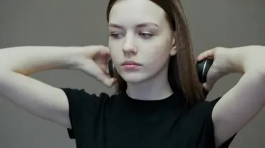Teenage girl puts on wireless headphones and enjoying music, dancing