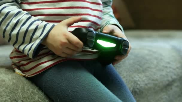 Dziecko z joystickiem w rękach bawiące się w gry komputerowe, mopsa z dzieckiem na kanapie w domu — Wideo stockowe