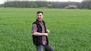 Çılgın başarılı çiftçi Yeşil tarlada dans ediyor.