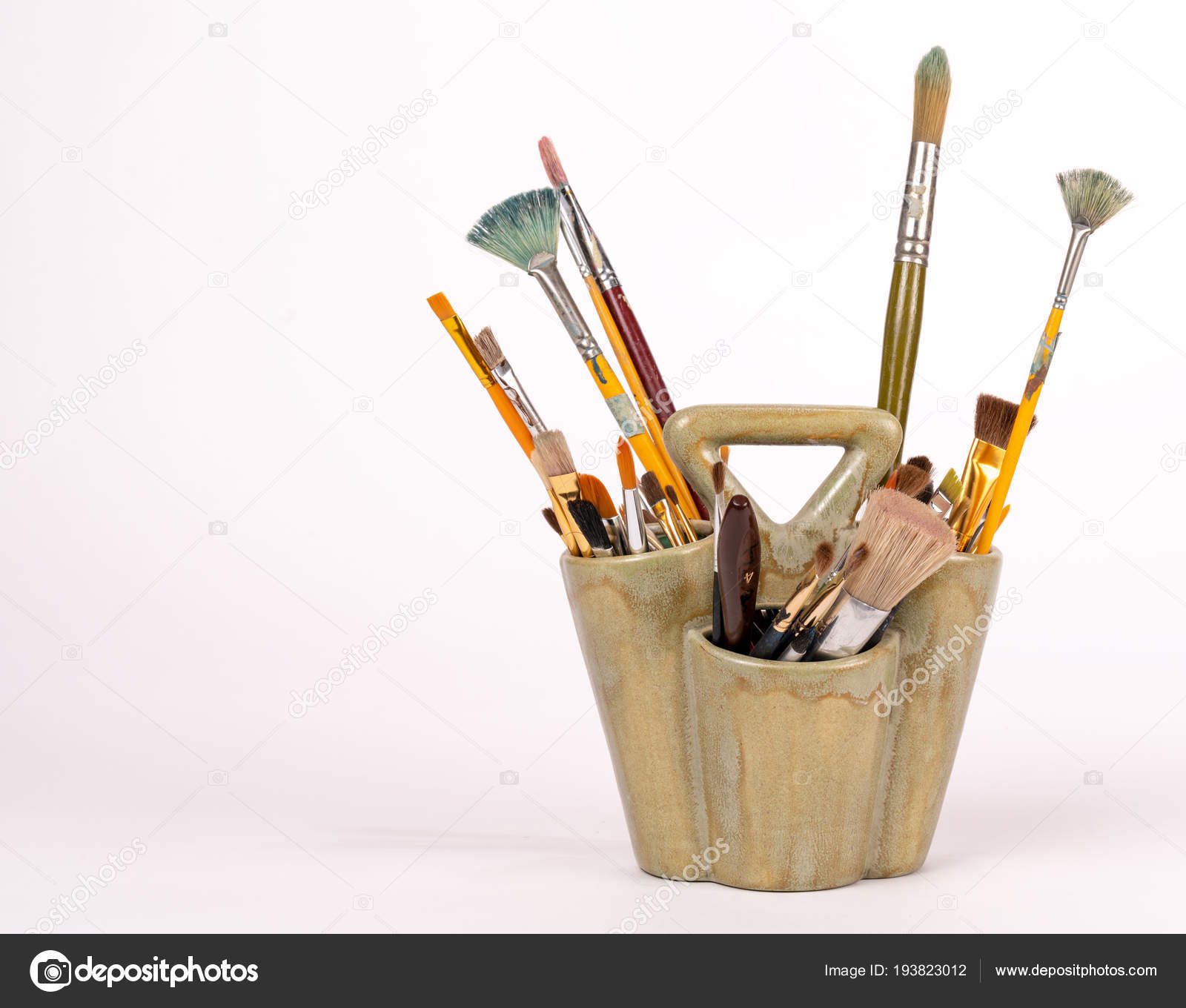 Paintbrushes Stand In A Vase Isolated On A White Background