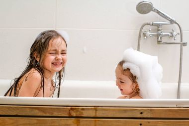 İki küçük kız kardeşi bir banyoda oyna.