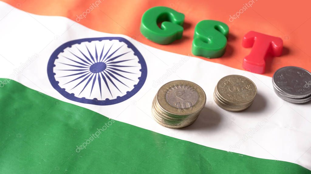 GST concept, GST alphabet and indian coins on Indian Flag background, business and financial india. Investment Saving and Corruption.