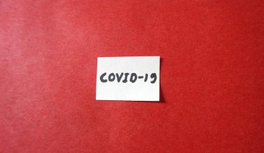 Kırmızı arka planda beyaz kağıda COVID-19 / Coronavirüs. Corona virüsünden etkilenen ekonomi ve finans piyasaları. düz yatış, metin için boşluk.