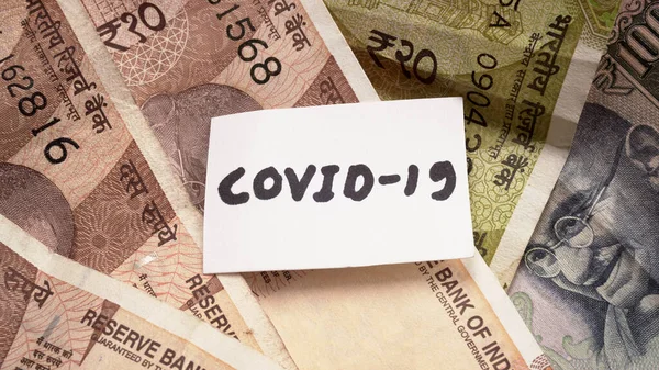 CORONA VIRUS ya da COVID-19 kelimeleriyle not et. Hindistan para birimi konsepti ekonomi ve finans piyasaları Corona virüsünden etkilenmiştir. düz yatış, metin için boşluk.