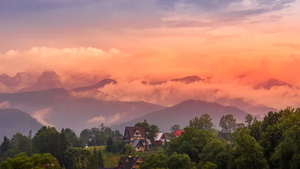 Polonya. Polonya Tatry dağları. Bulutlu dağların manzarası. Arka plandaki evlerde.