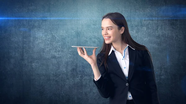 Beautiful smiling businesswoman is holding the tray and looking at something — Stock Photo, Image