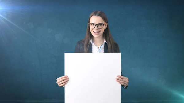 Sorriso Retrato de mulher de negócios com placa branca em branco em azul isolado. Modelo feminino com cabelo comprido em óculos . — Fotografia de Stock