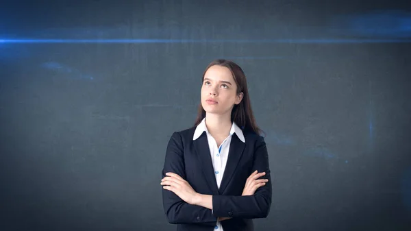 Beautiful businesswoman with arms folded looking up at copyspace. Standing over gray background. — Stock Photo, Image
