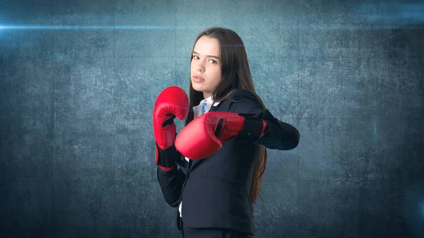 Joven hermosa mujer en traje negro y camisa blanca de pie en la pose de combate con guantes de boxeo rojo. Concepto empresarial . —  Fotos de Stock