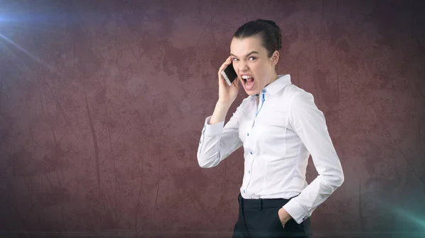 Femme d'affaires en colère, debout à côté, parlant par téléphone portable, hurlant émotionnellement, criant. Fond de studio isolé — Photo