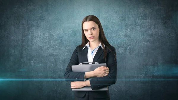 Young serious beautiful businesswoman portrait with gray briefcase, dark background — Stock Photo, Image