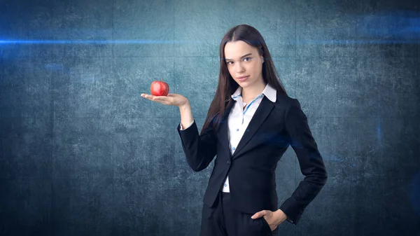 Takım elbiseli kız parlak canlı elma elinde, yeni fikirler ve yeni kavramları ya da ofiste sağlıklı yaşam tarzı bayraklarında tutar