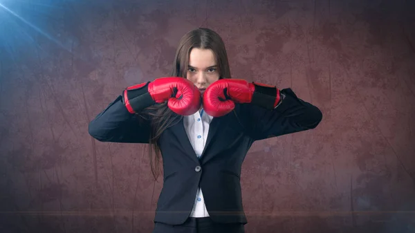 Siyah takım elbise ve beyazlı duran kırmızı boks eldivenleri ile mücadele poz genç güzel kadın. İş kavramı. — Stok fotoğraf