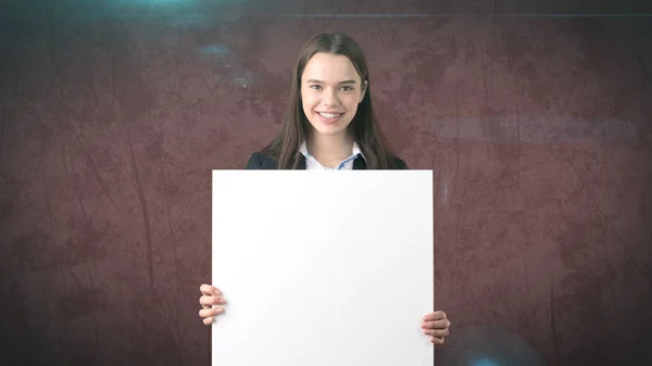 Leende Business kvinna stående med tomma vita ombord på brun isoleras. Kvinnlig modell med långt hår. — Stockfoto