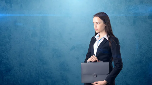 Retrato de mujer de negocios hermosa seria joven con maletín gris, fondo oscuro —  Fotos de Stock