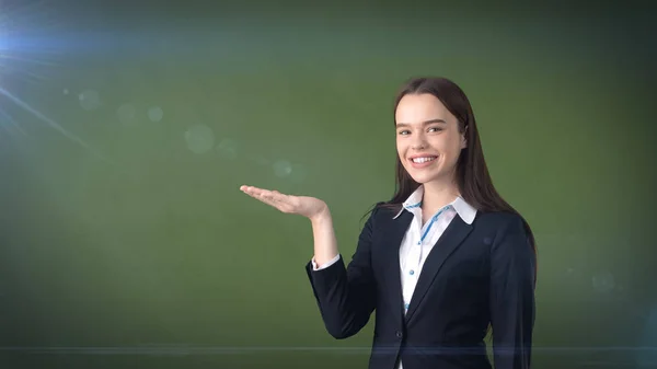 Bella donna d'affari guardando la sua mano e sorridente, sfondo verde — Foto Stock