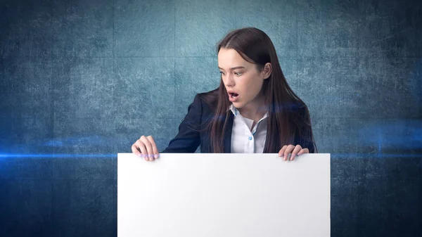 Retrato de mulher de negócios surpreso com placa branca em branco em azul isolado. Modelo feminino com cabelo comprido . — Fotografia de Stock